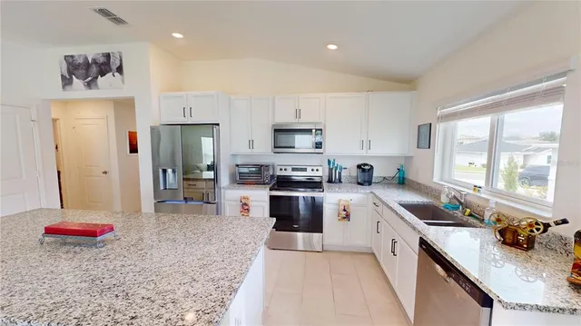 a kitchen with stainless steel appliances granite countertop a refrigerator sink and stove