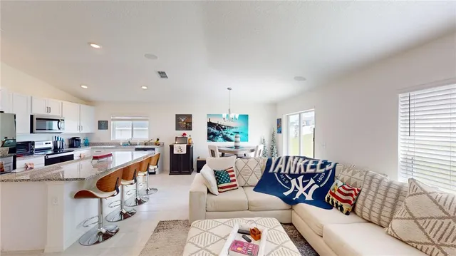 a living room with furniture and kitchen view