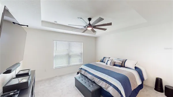 a bedroom with a bed and a ceiling fan