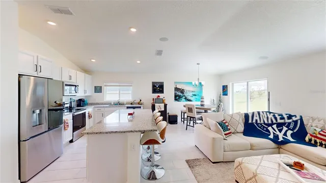 a living room with furniture flat screen tv and a refrigerator