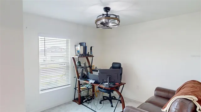 a view of a workspace with furniture and a window