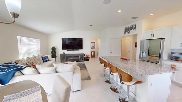 a large living room with stainless steel appliances furniture a flat screen tv
