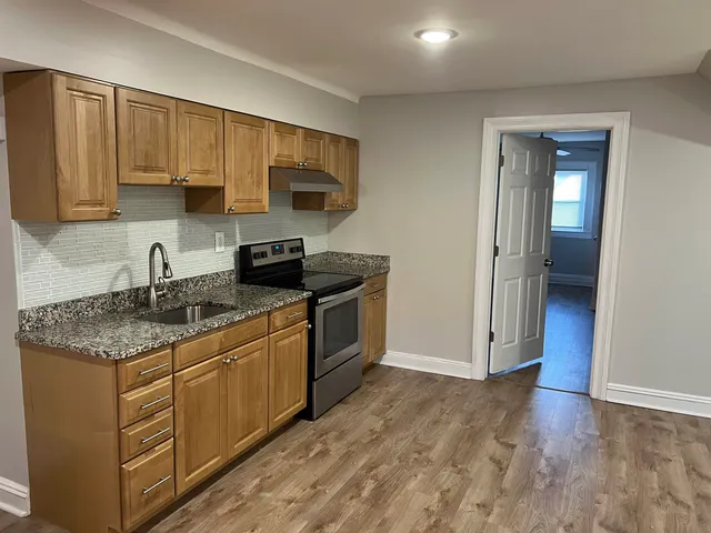 an empty room with wooden floor and mirror