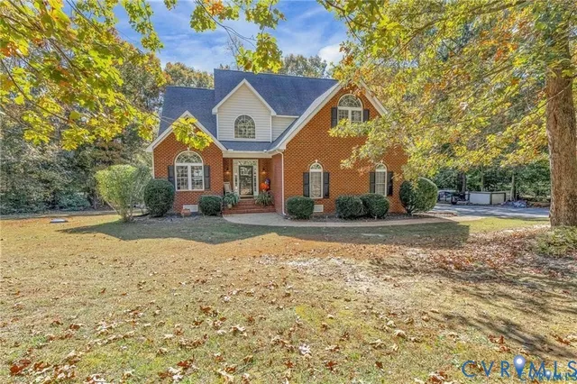 a view of house with yard and parking
