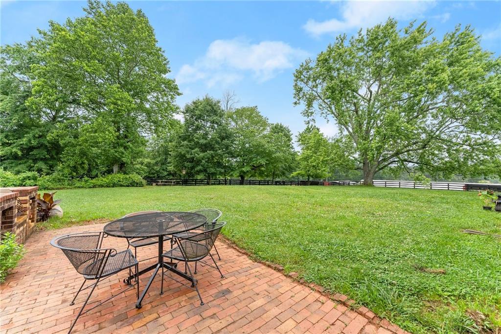 7215 Kelly Bridge Road Dawsonville, GA 30534 - Photo 48 of 87 a view of a lake with table and chairs under an umbrella