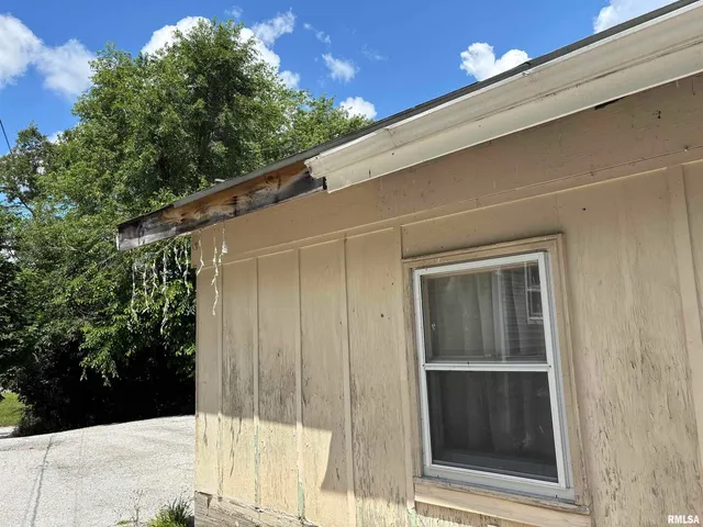a backyard of a house with table and chairs with wooden fence