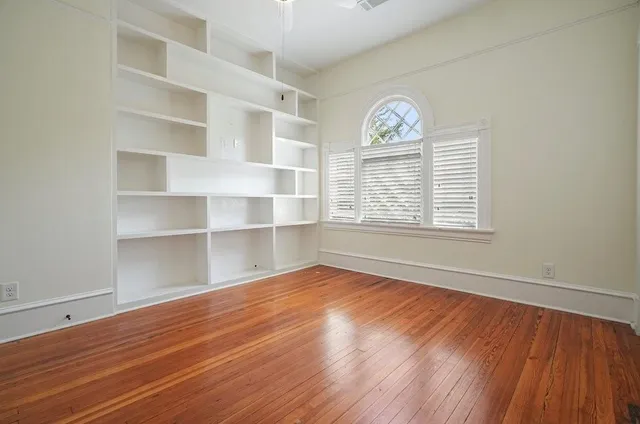a view of a room with wooden floor and a window