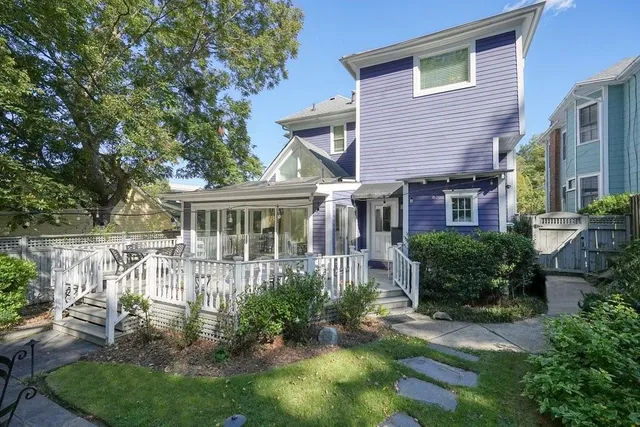 a front view of a house with a yard and potted plants