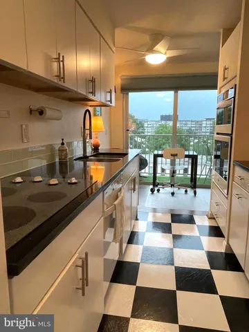 a kitchen with a sink and a black white checkered floor