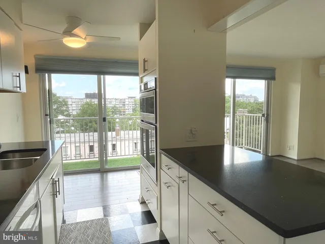 a view of open kitchen with granite countertop a large window and a sink