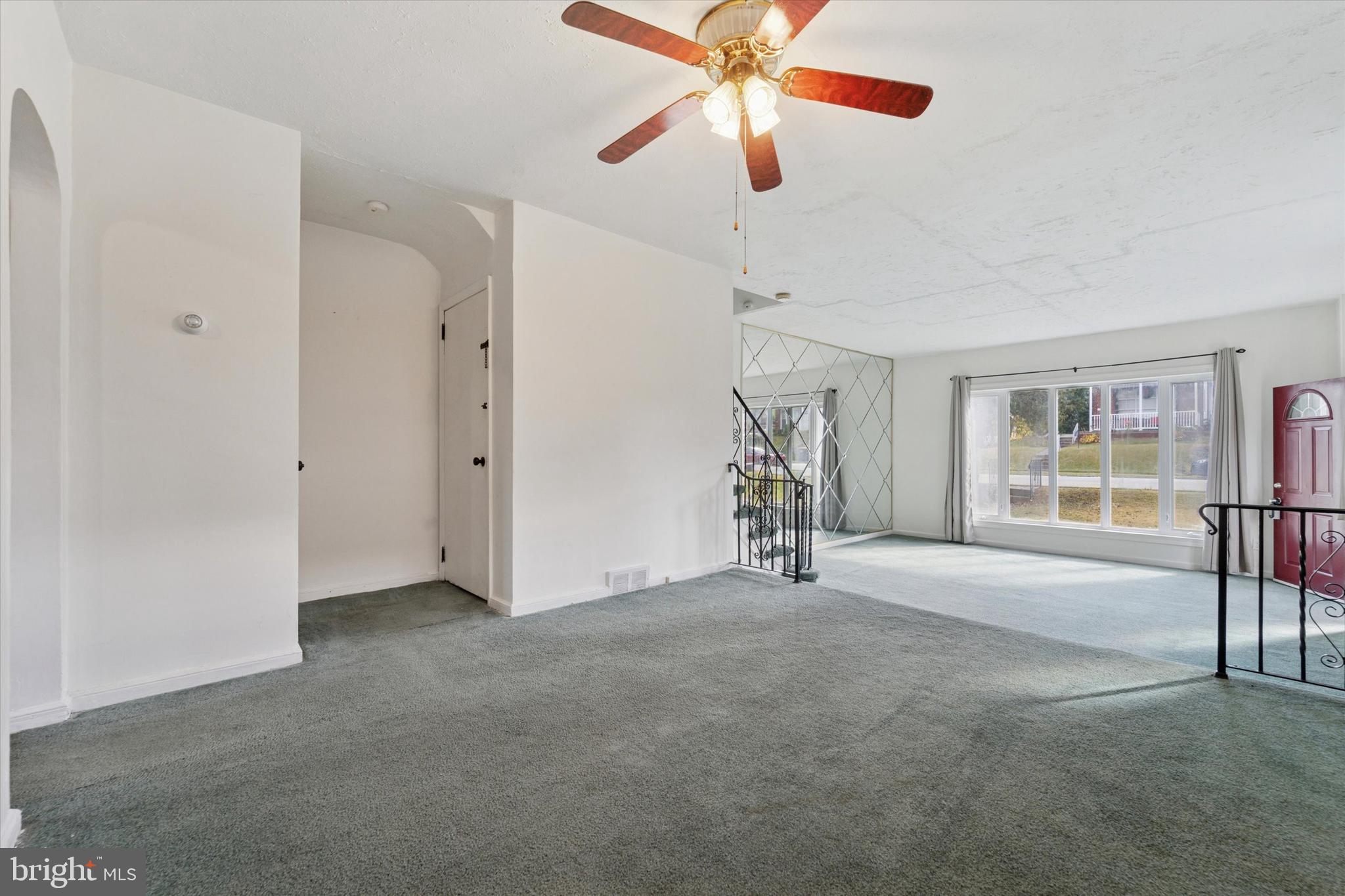 732 East 25th Street Chester, PA 19013 - Photo 7 of 25 an empty room with chandelier fan and windows