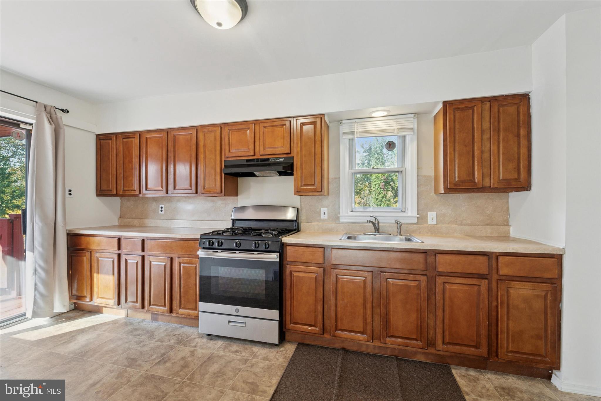732 East 25th Street Chester, PA 19013 - Photo 8 of 25 a kitchen with stainless steel appliances granite countertop a stove sink and cabinets