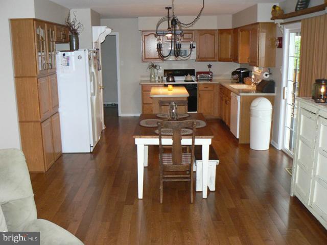 1739 Canal Run Drive Point of Rocks, MD 21777 - Photo 20 of 30 a kitchen with stainless steel appliances granite countertop a refrigerator a stove top oven a sink dishwasher and a dining table with wooden floor