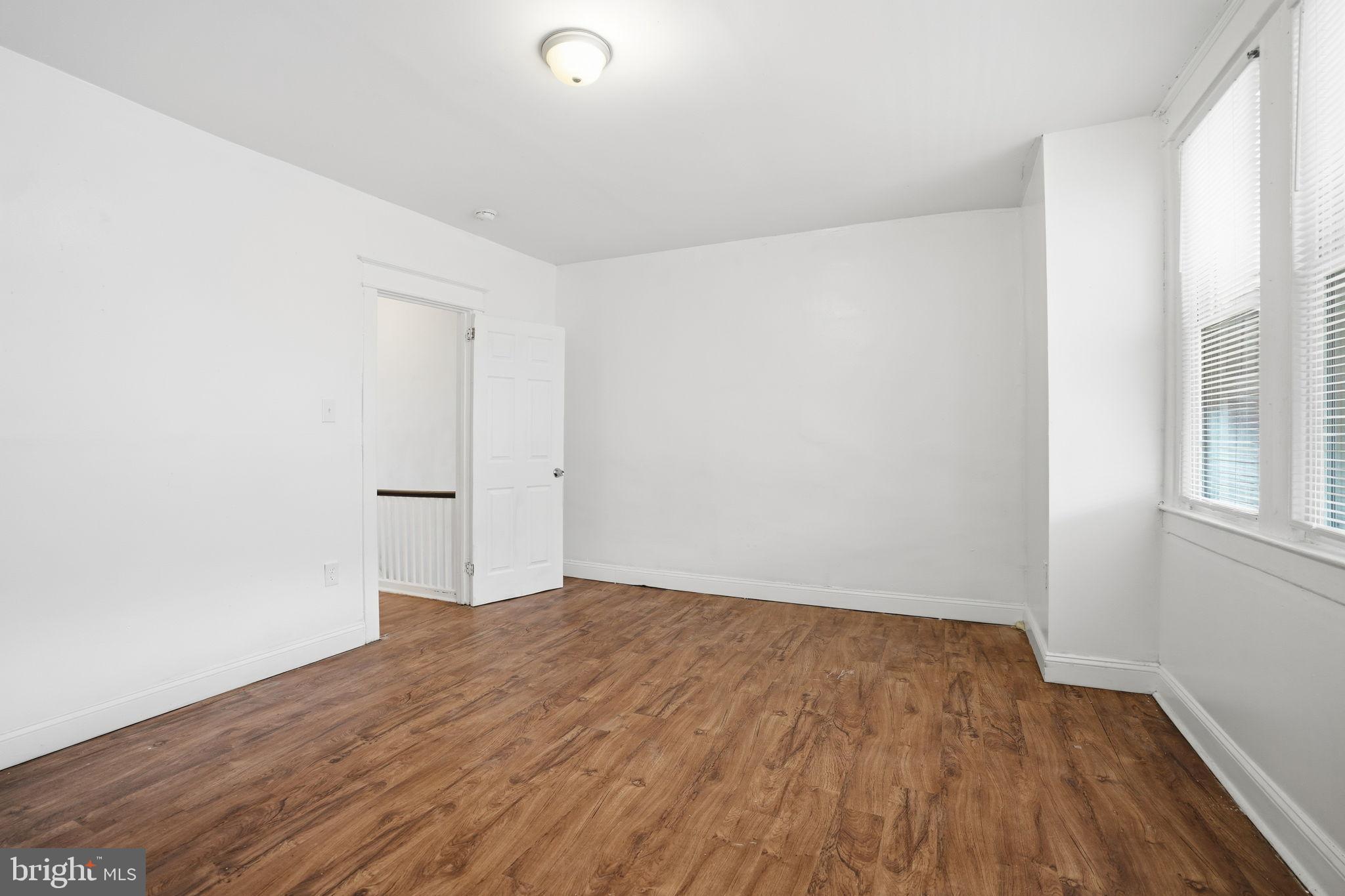 5563 Blakemore Street Philadelphia, PA 19138 - Photo 16 of 22 an empty room with wooden floor and windows