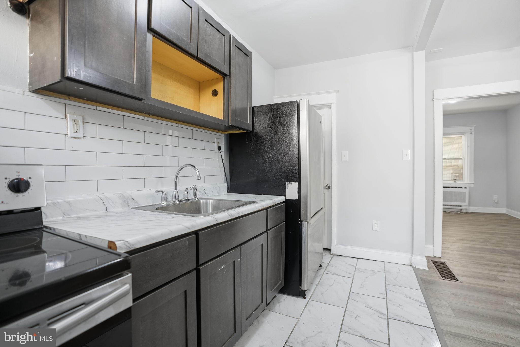 5563 Blakemore Street Philadelphia, PA 19138 - Photo 8 of 22 a kitchen with a sink refrigerator and cabinets