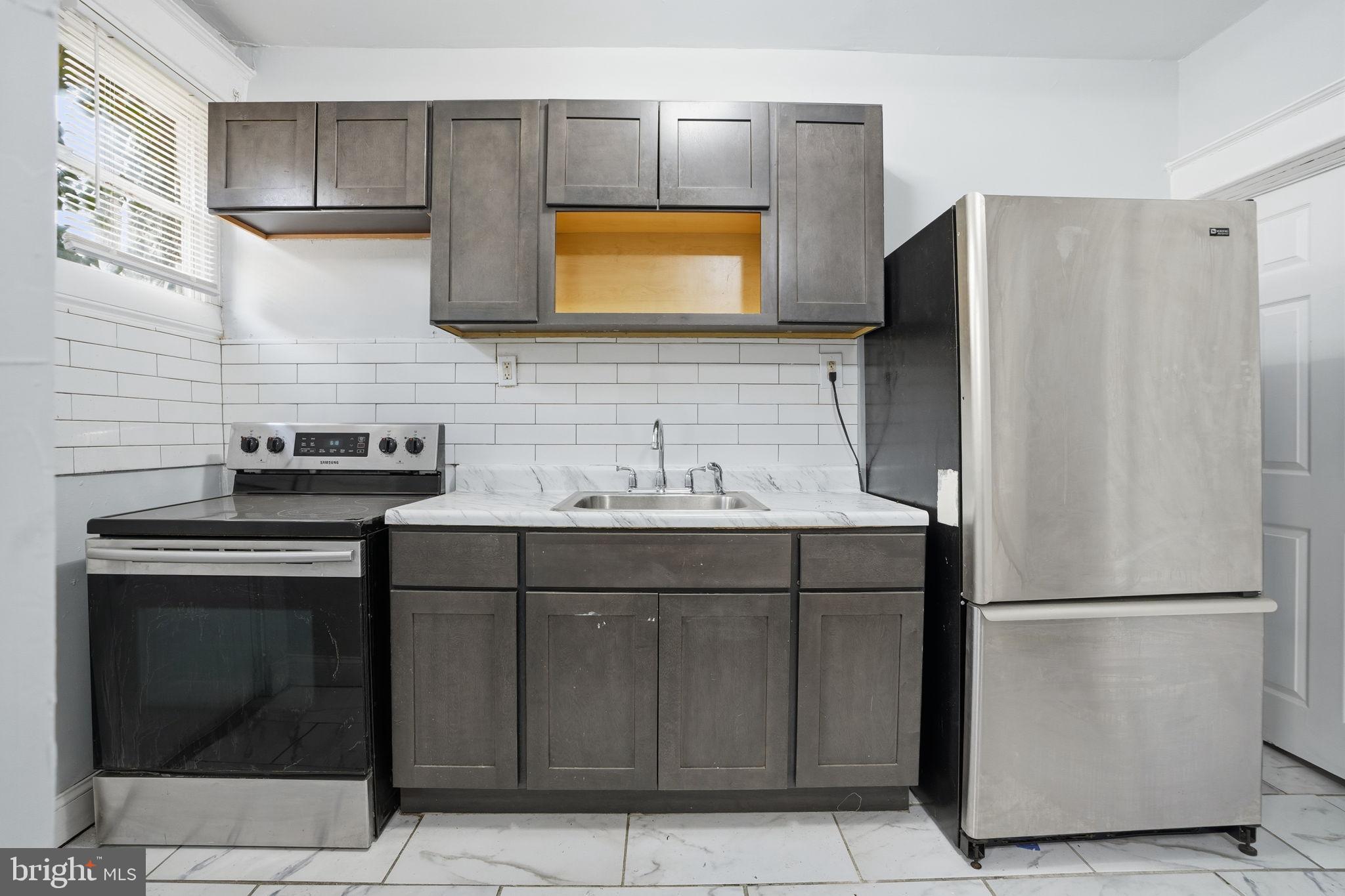 5563 Blakemore Street Philadelphia, PA 19138 - Photo 9 of 22 a kitchen with a sink and a refrigerator