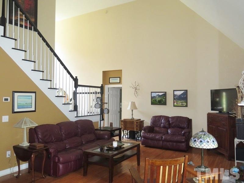 7801 Housewren Place Raleigh, NC 27613 - Photo 5 of 23 a living room with furniture couches and a dining table with wooden floor