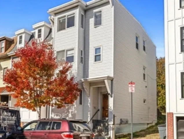 a front view of a building with large trees