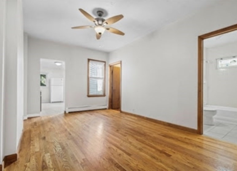 156 Lexington Street, Unit 1 Boston, MA 02128 - Photo 7 of 12 a view of an empty room with wooden floor and a window