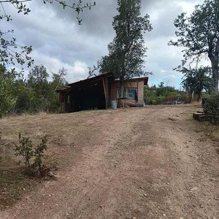 a view of a dry yard with wooden fence