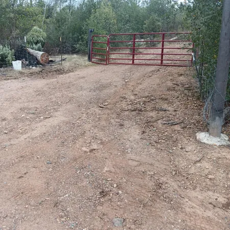 a view of backyard with wooden fence and a bench