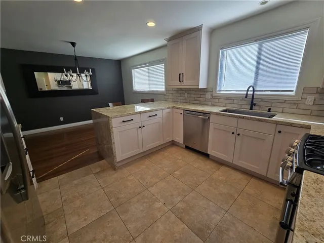a kitchen with granite countertop a refrigerator and a stove top oven