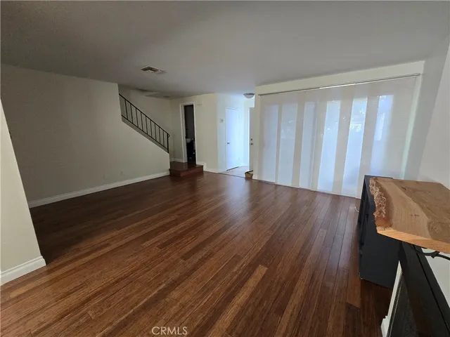 a view of a hallway with wooden floor and stairs