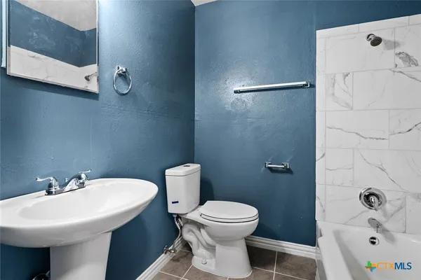 a bathroom with a sink a toilet and bathtub