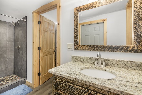 1519 Tipton Springs Road Morganton, GA 30560 - Photo 13 of 46 a bathroom with a granite countertop sink a mirror and a shower