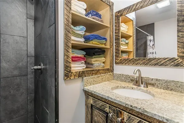 a bathroom with a granite countertop sink and a mirror