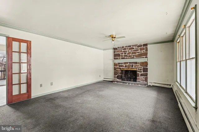 an empty room with a fireplace and window