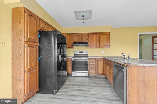a kitchen with granite countertop a refrigerator stove and oven