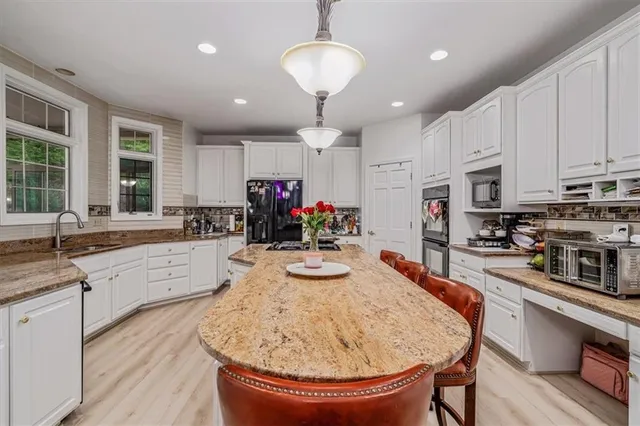 a kitchen with sink a stove and chairs