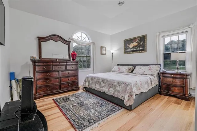 a bedroom with a bed and wooden floor