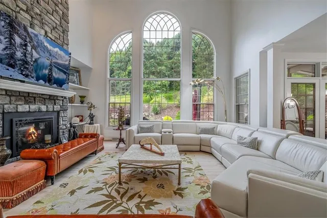 a living room with furniture fireplace and a large window