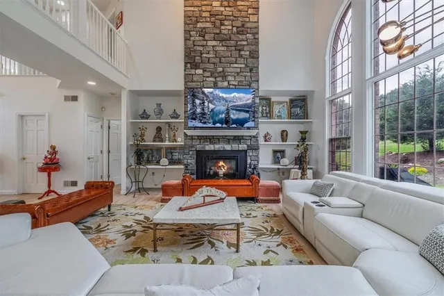 a living room with fireplace furniture and a large window