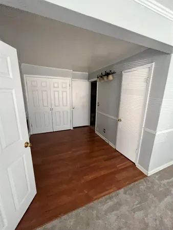 an empty room with wooden floor and entrance