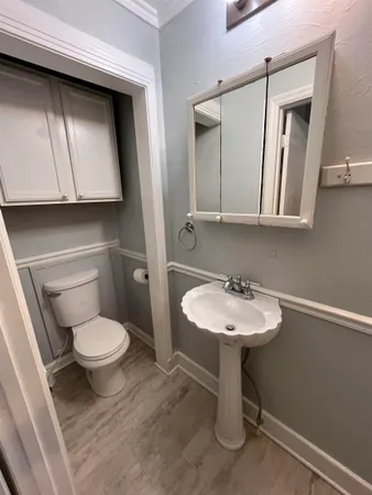 a bathroom with a sink toilet and mirror