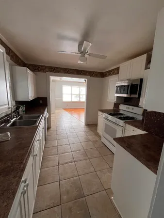 a kitchen with granite countertop a stove a sink dishwasher and a microwave