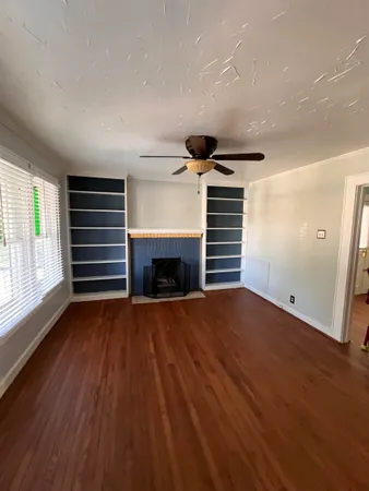 a view of empty room with wooden floor and fireplace