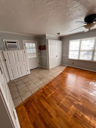 a view of an empty room with a window and wooden floor