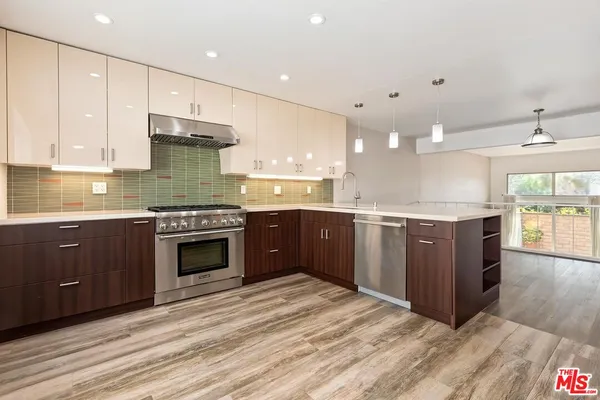 a large kitchen with stainless steel appliances granite countertop a stove and a sink