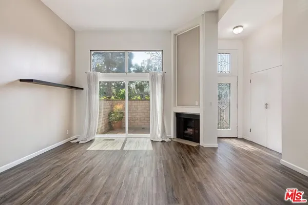 wooden floor fireplace and windows in an empty room