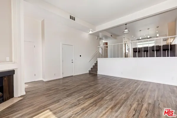 a view of a big room with wooden floor and windows