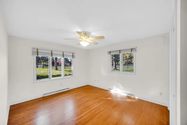 a view of empty room with a window and a ceiling fan