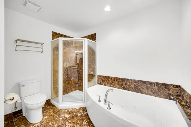 a bathroom with a tub a sink and mirror