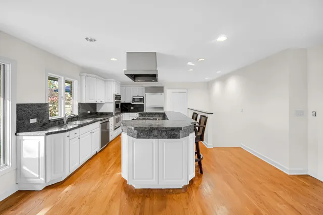 a large kitchen with stainless steel appliances granite countertop a stove a sink and a granite counter tops