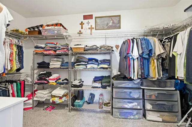 a view of walk in closet with clothes and shoes