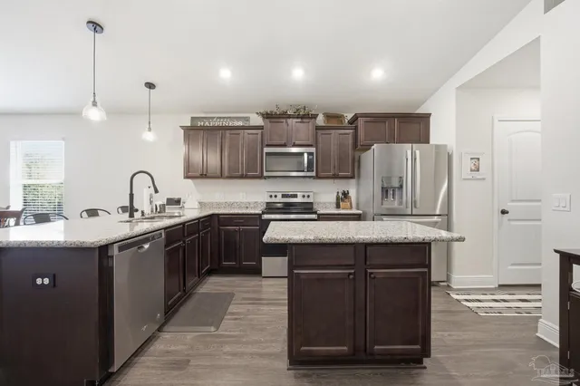a kitchen with stainless steel appliances granite countertop a sink stove and refrigerator