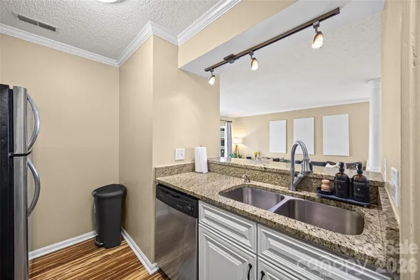 a kitchen with a sink and a large mirror next to a window